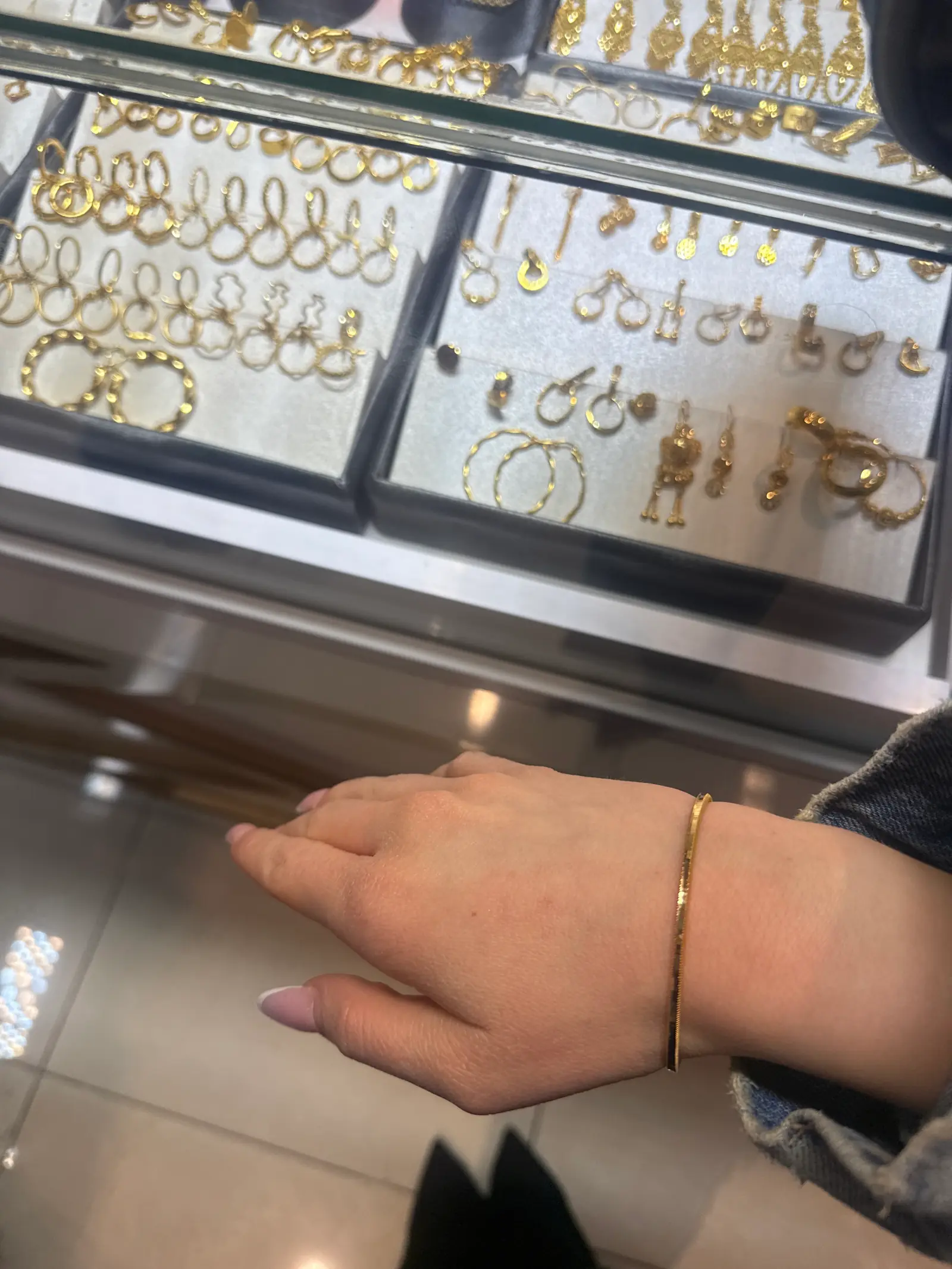 Beratung an der Vitrine bei Adibelli Gold, Armreif am Handgelenk